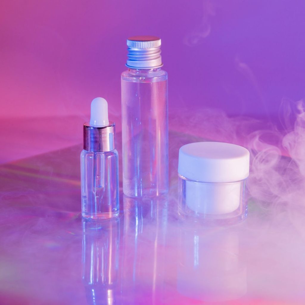 Product photography image of beauty products on a purple background with dry ice